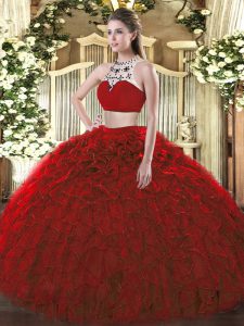 Vestido rojo brillante de quinceañera sin espalda con cuello alto, dos piezas de tul sin mangas y volantes.