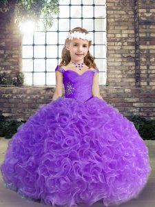 Los niños visten un vestido de color púrpura con tiras de tela y flores sin mangas hasta el suelo