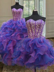 Tres pedazos azules y púrpuras de los vestidos de bola del organza que rebordean sin mangas y rizan la longitud del piso atan para arriba el vestido de quinceanera